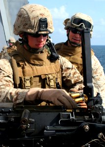 US Navy 081004-N-6764G-150 Lance Cpl. Kyle Vantine loads a .50 caliber machine gun
