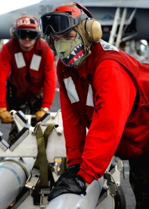US Navy 081001-N-7571S-007 Aviation Ordnanceman 2nd Class Charles Block transfers inert missiles from the flight deck to the