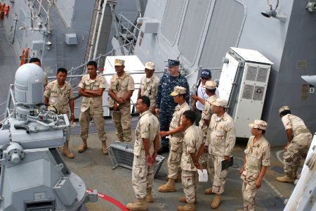 US Navy 101204-N-4780J-032 Chief Machinery Repairman Tim Groeneveld shows a 25 mm chain gun to Royal Cambodia Navy sailors during a tour of the gui