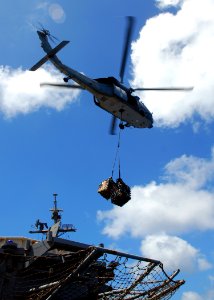 US Navy 080929-N-2183K-029 An MH-60S Sea Hawk lowers a cargo pendant onto the flight of the deck of the amphibious assault ship USS Peleliu (LHA 5)