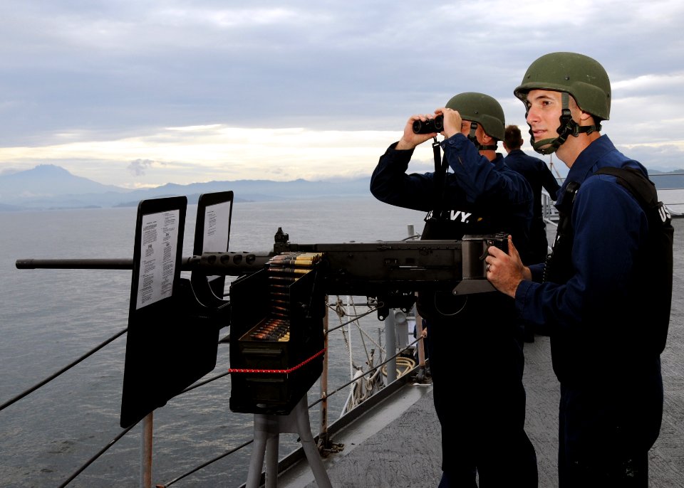 US Navy 110128-N-5620H-082 Gunner's Mate 1st Class Curtis Luttrell and Gunner's Mate 2nd Class Steven Berrey keep watch as USS Frank Cable (AS 40)