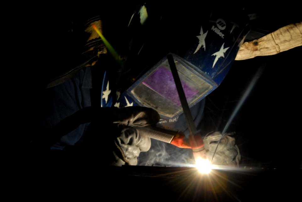 US Navy 080929-N-3610L-066 Hull Maintenance Technician Fireman Wayne Worley demonstrates to his junior firemen how to weld on a sheet of aluminum