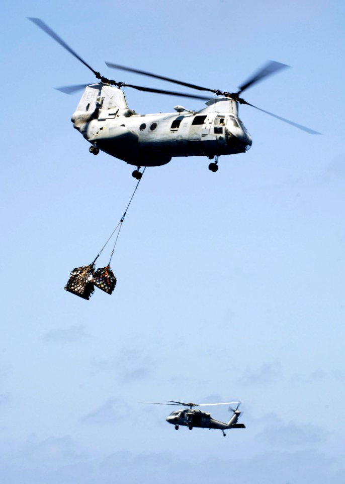 US Navy 081002-N-4236E-146 H-46E Sea Knight helicopter assigned to Marine Medium Helicopter Squadron (HMM) 264 and an MH-60S Sea Hawk helicopter assigned to Helicopter Sea Combat Squadron (HSC) 26 participate in a vertical repl