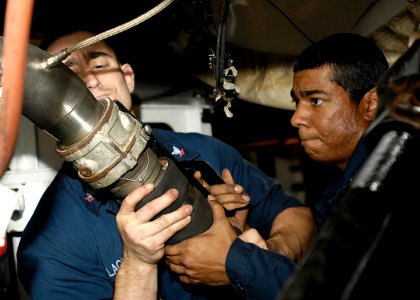 US Navy 081002-N-4954I-004 Aviation Machinist's Mate 3rd Class Anthony Blackner, left, from Jacksonville, Fla., and Aviation Machinist's Mate 3rd Class Ryan Fingall, from Niceville, Fla., connect an air hose to the engine of an