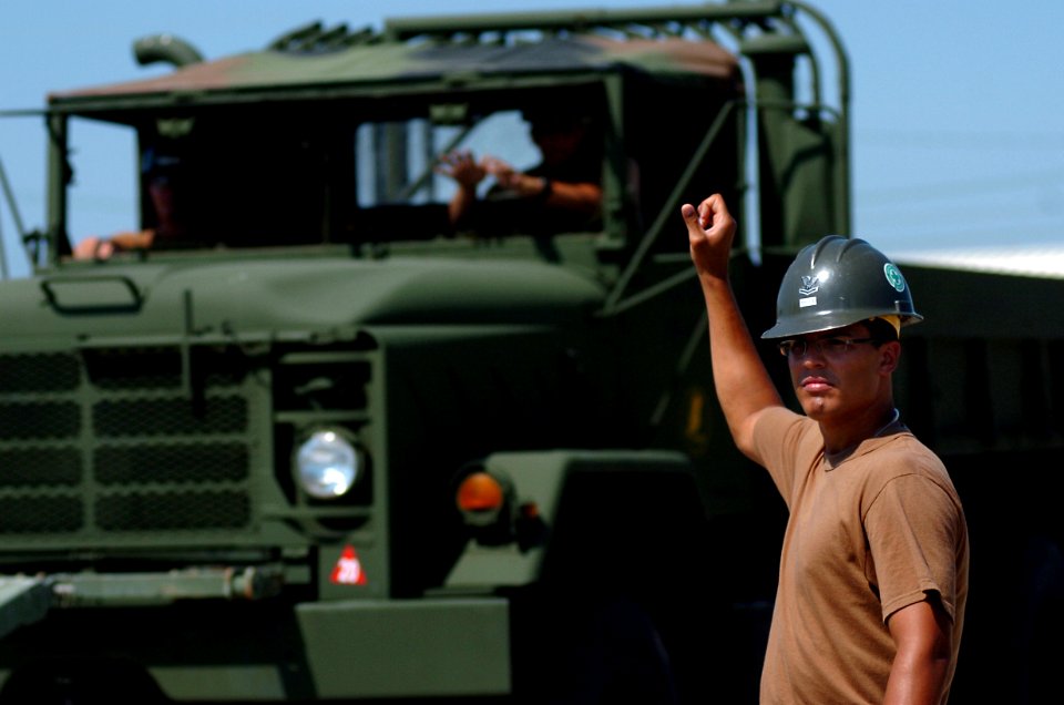 US Navy 080930-N-3674H-133 Builder 2nd Class Stephen Leguillow guides the driver of a medium tactical vehicle