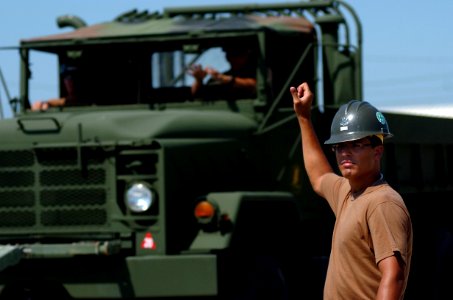 US Navy 080930-N-3674H-133 Builder 2nd Class Stephen Leguillow guides the driver of a medium tactical vehicle