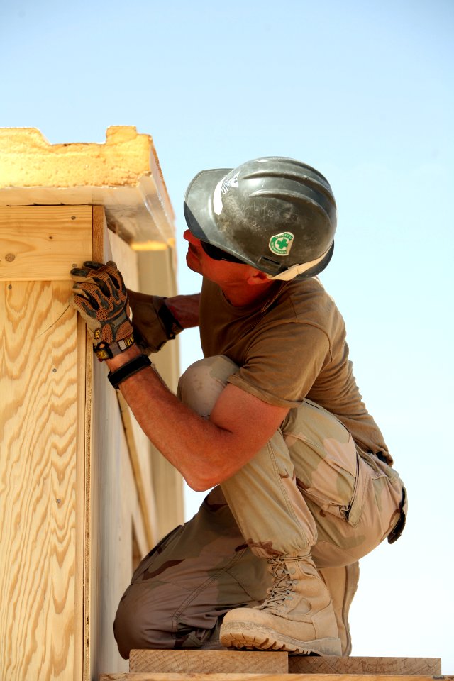 US Navy 081006-N-9623R-202 Builder 1st Class Scott Taylor works finishing the roof section on a South West Asia hut