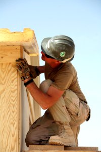 US Navy 081006-N-9623R-202 Builder 1st Class Scott Taylor works finishing the roof section on a South West Asia hut photo