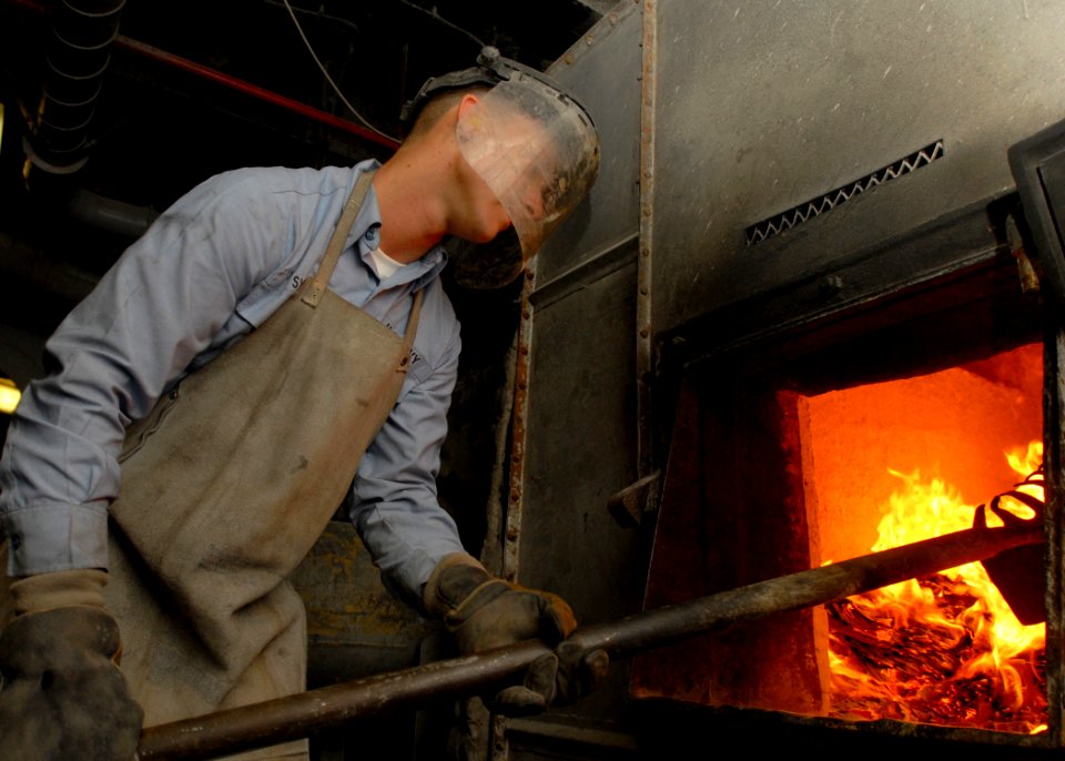 US Navy 081003-N-2456S-020 Aviation Electronics Technician Airman Eric Syck burns trash in the incinerator aboard the aircraft carrier USS Theodore Roosevelt (CVN 71)