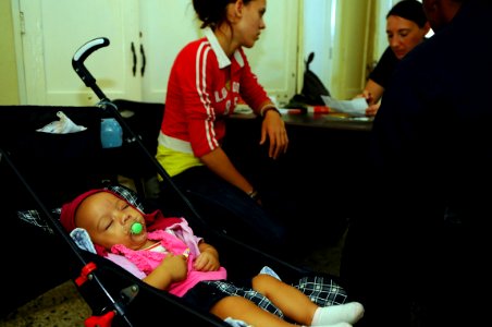 US Navy 081005-N-4515N-027 Air Force Capt. Bethany Mikles and Navy translator Seaman Franklin Lopez, speak with a Dominican woman as her baby sleeps in a stroller