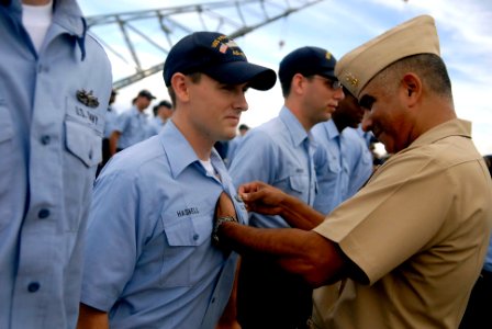 US Navy 081003-N-9818V-174 Master Chief Petty Officer of the Navy (MCPON) Joe R. Campa Jr. pins on the Enlisted Surface Warfare Specialist pin to Culinary Specialist 2nd Class during an all-hands call on the submarine tender US