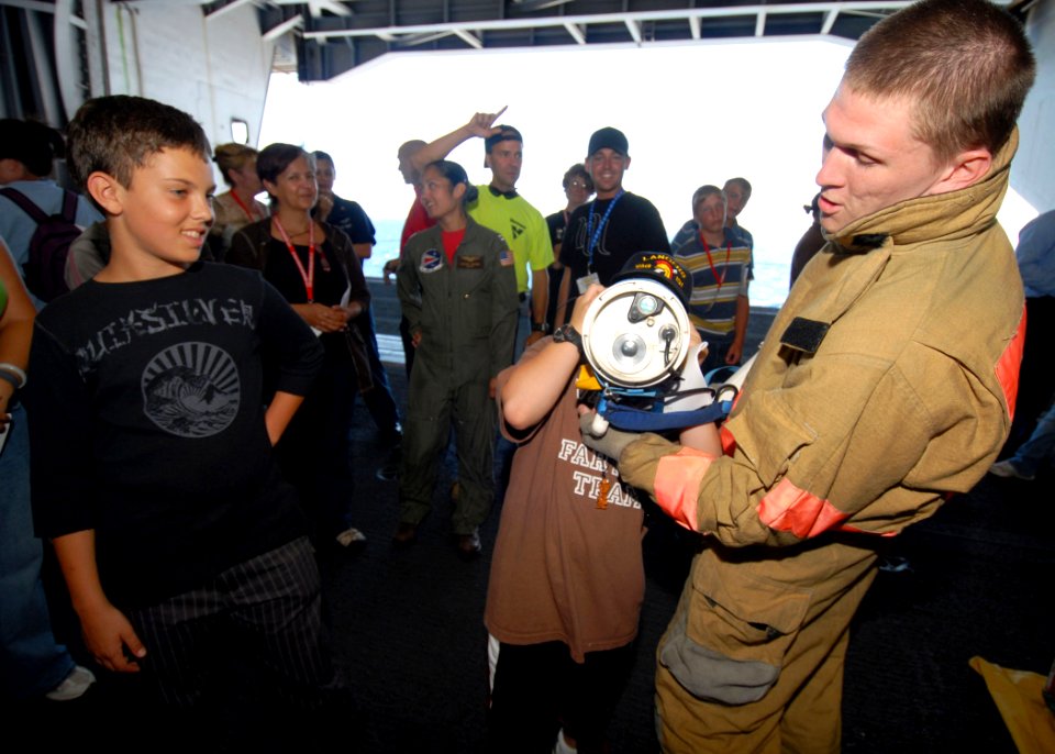 US Navy 081003-N-9079D-056 Damage Controlman Fireman Andy Ketchum, from Springfield, Ore., shows Tigers Cruise participants how to use a Navy Infrared Thermal Imager in the hangar bay aboard the aircraft carrier USS Abraham Lin