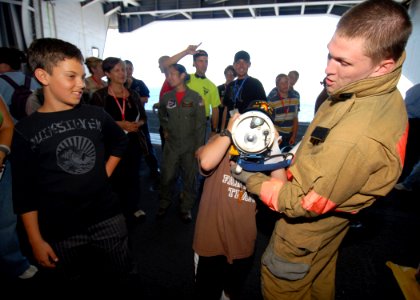 US Navy 081003-N-9079D-056 Damage Controlman Fireman Andy Ketchum, from Springfield, Ore., shows Tigers Cruise participants how to use a Navy Infrared Thermal Imager in the hangar bay aboard the aircraft carrier USS Abraham Lin