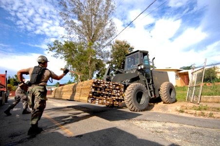 US Navy 081004-N-9620B-001 Service members unload construction supplies