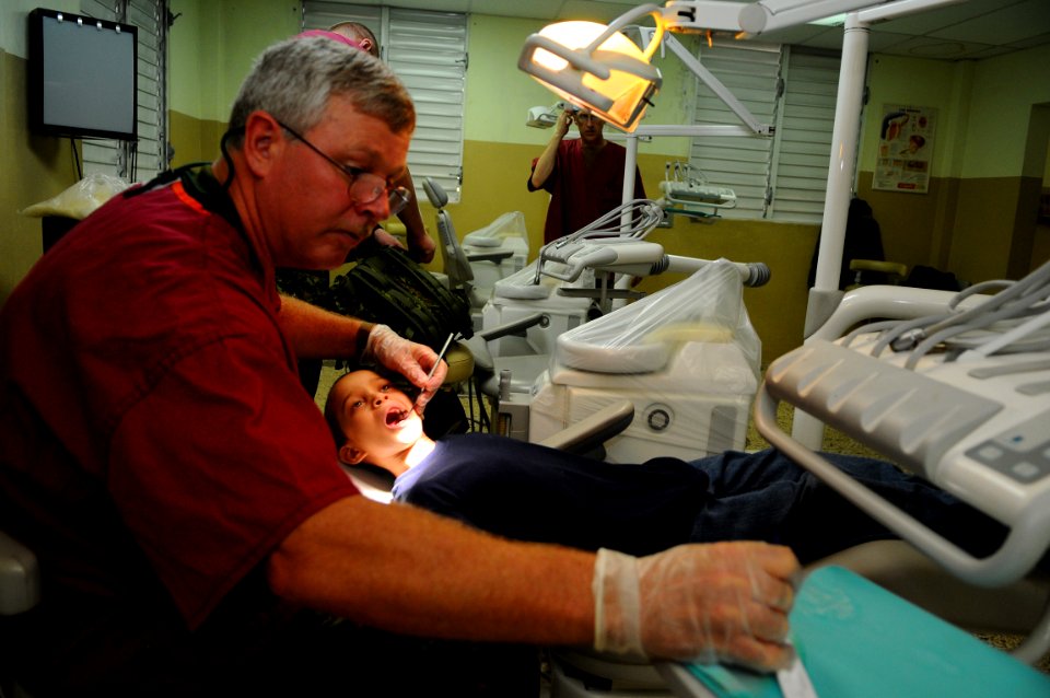 US Navy 081004-N-4515N-035 Canadian Army dentist Maj. Brian Walker, embarked aboard the amphibious assault ship USS Kearsarge (LHD 3), puts fluoride on the teeth of a child