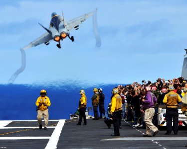 US Navy 081006-N-7981E-278 Tiger Cruise participants aboard the aircraft carrier USS Abraham Lincoln (CVN 72) watch from behind the flight deck foul lines as an F-A-18C Hornet assigned to