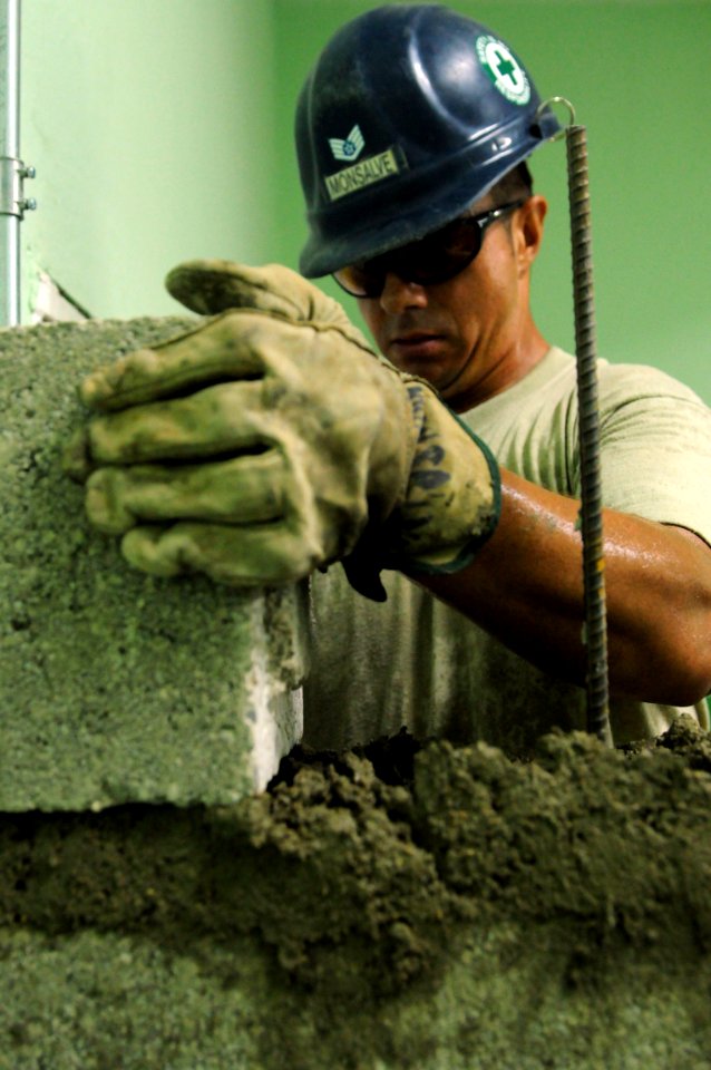 US Navy 081005-N-5642P-082 Air Force Staff Sgt. Richard Monsalve sets a cinder block onto mortar