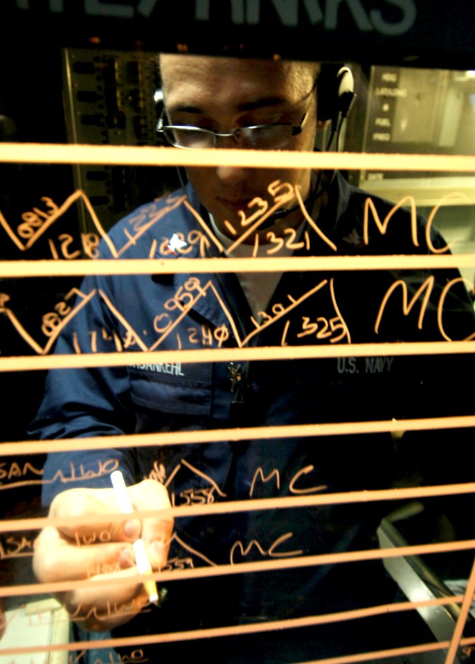US Navy 081002-N-4236E-219 Air Traffic Controller 3rd Class Joshua Ochsankehl updates a status board aboard the multi-purpose amphibious assault ship USS Iwo Jima (LHD 7)