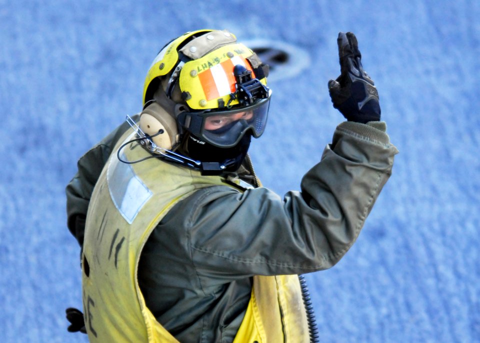 US Navy 081007-N-2183K-058 A flight deck crewman uses hand signals to direct aircraft on the flight deck aboard the amphibious assault ship USS Peleliu (LHA 5) during routine flight operations