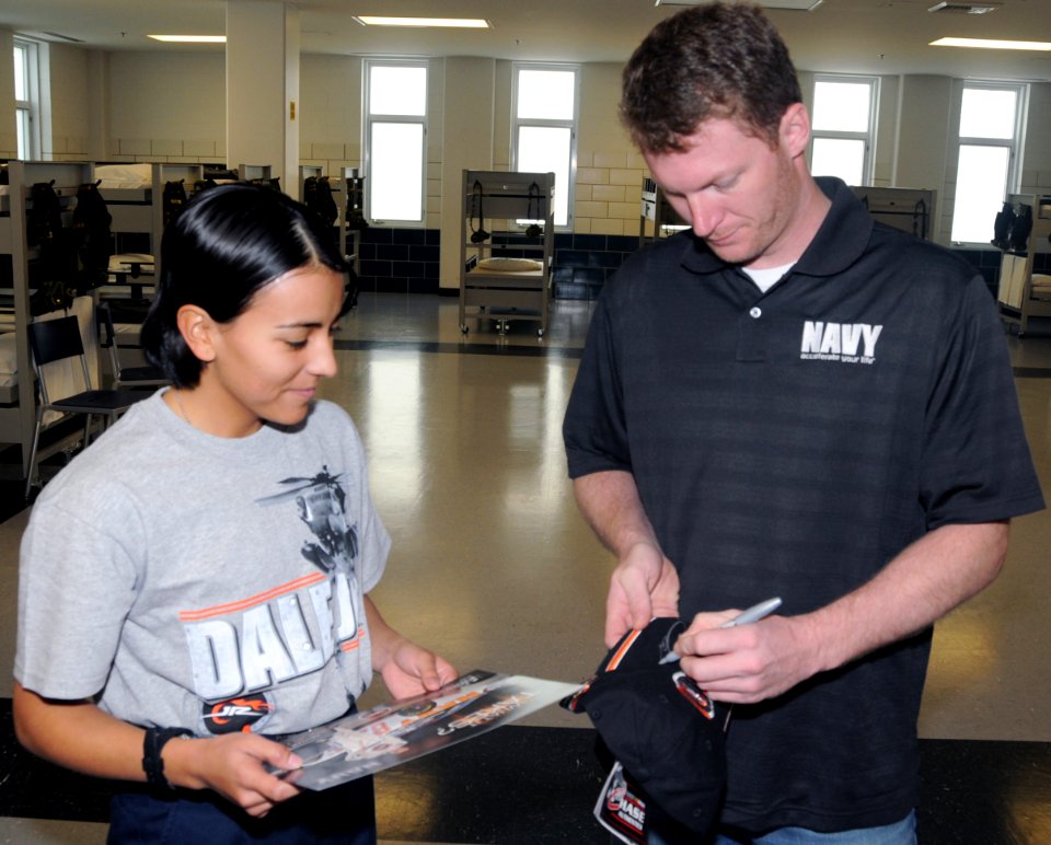 US Navy 081007-N-8848T-889 Dale Earnhardt Jr. autographs a hat for Seaman Recruit Heather Martinez