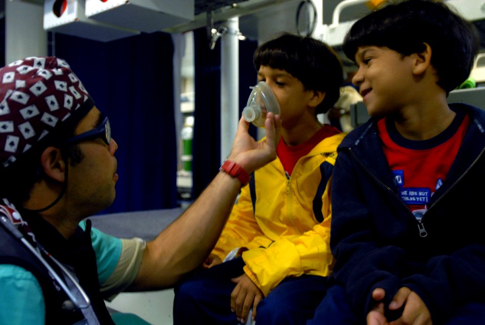 US Navy 081010-N-3595W-745 Anesthesiologist Enrique Abreu prepares twin brothers for eye surgery