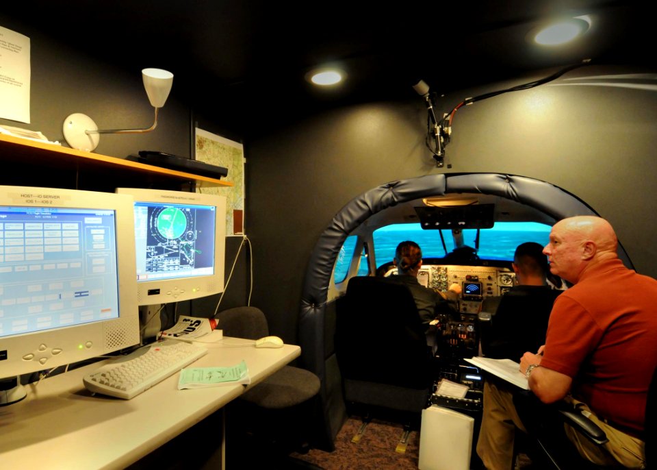 US Navy 081008-N-2728S-071 Ensign Ruth Roberson and Air Force 2nd Lt. Denny Paulson take flight in the TC12B Visual Simulator during ground training exercises