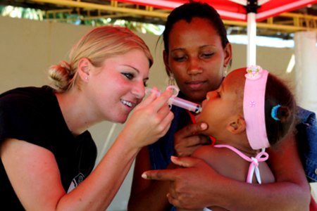US Navy 081010-N-7955L-085 Air Force Senior Airman Alex Olson administers de-worming medication to a young patient