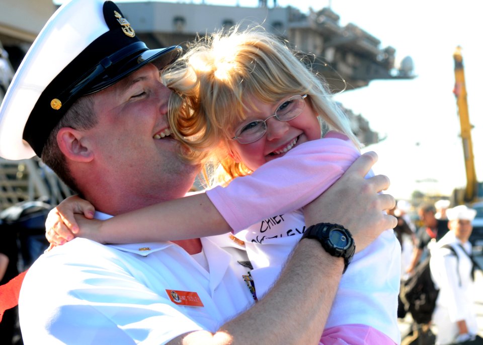 US Navy 081008-N-6736G-061 Chief Aviation Warfare Systems Operator Michael Ousley embraces his daughter after the aircraft carrier USS Abraham Lincoln (CVN 72) moors pier side at Naval Station North Island