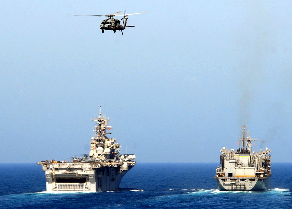 US Navy 081009-N-9134V-046 An MH-60S Sea Hawk from Helicopter Sea Combat Squadron (HSC) 26 flies over the multi-purpose amphibious assault ship USS Iwo Jima (LHD 7) and Military Sealift Command fleet combat support ship USNS Br