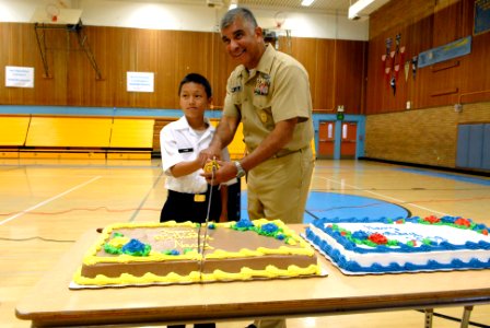US Navy 081008-N-9818V-269 Master Chief Petty Officer of the Navy (MCPON) Joe R. Campa Jr. cuts the Navy birthday cake with the youngest member in the Junior Reserve Officer Training Corps (JROTC) program at Luther Burbank High