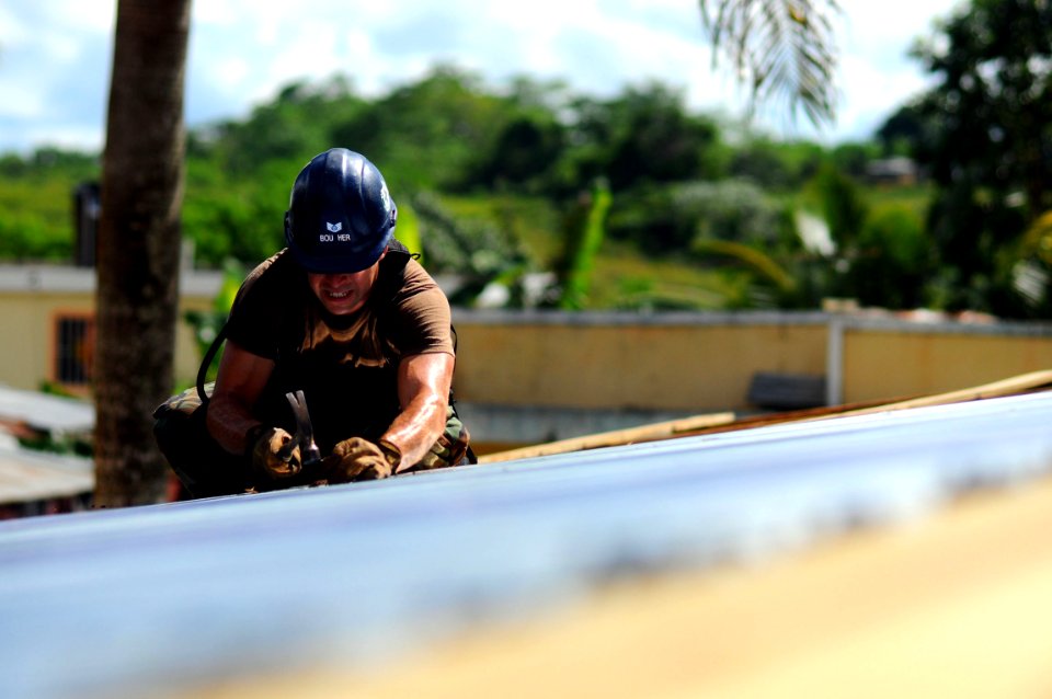 US Navy 081009-N-4515N-144 Air Force Tech Sgt. Scott Boucher works on the roof of a school house