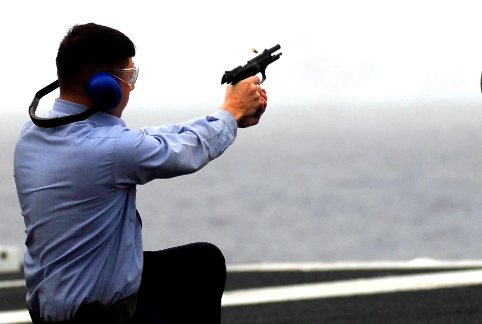 US Navy 081009-N-9928E-084 Fire Controlman 2nd Class Richard Eisenring, from Port Richey, Fla., fires a 9mm pistol during small arms qualification aboard the Nimitz-class aircraft carrier USS John C. Stennis (CVN 74)