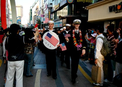 US Navy 081009-N-1062H-199 Sailors and officers from USS George Washington (CVN 73), USS Cowpens (CG 63) and USS John S. McCain (DDG 56) participate in the Busan Jagalchi Festival parade and wave to onlookers