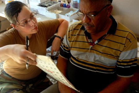 US Navy 081007-N-3595W-029 Interior Communication Specialist 3rd Class Danielle Ybarra, assigned to the amphibious assault ship USS Kearsarge (LHD 3), examines patients at a local optometry clinic during a community service pro