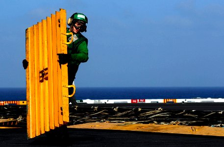 US Navy 081010-N-9928E-042 Aviation Boatswain's Mate (Equipment) Airman Zach Hill removes a barricade deck ramp