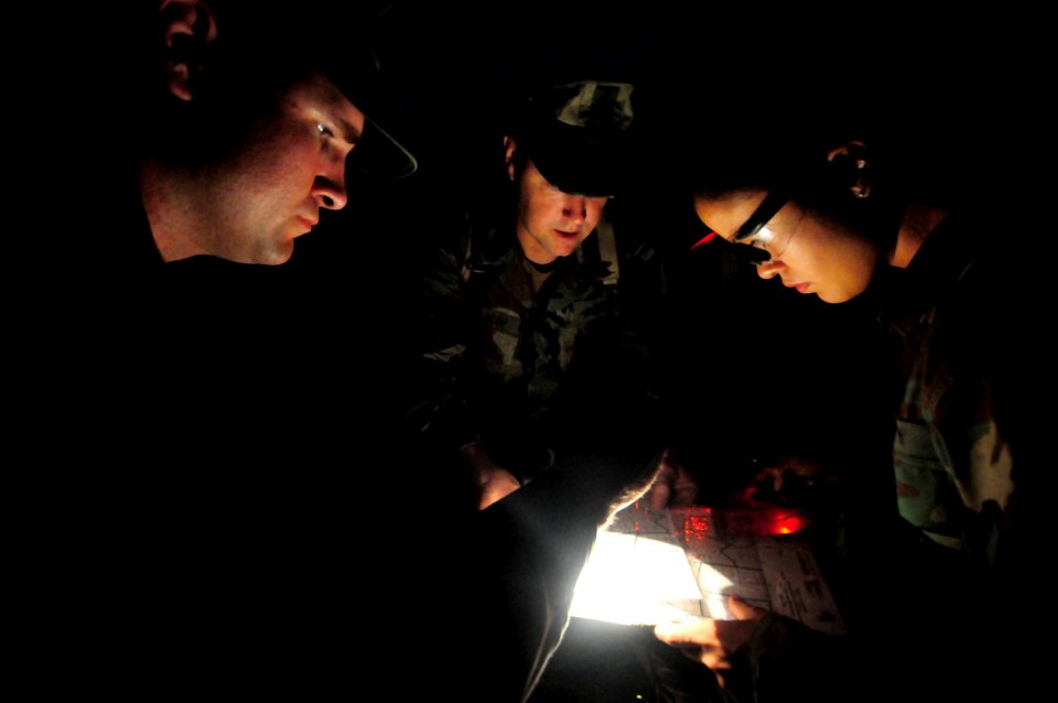US Navy 081010-N-0411D-051 Construction Electrician 1st Class Sean Dement, left, Senior Chief Equipment Operator George Waldrop, and Information Technology Specialist Jamie Marshall plot a map point during a Navy Expeditionary