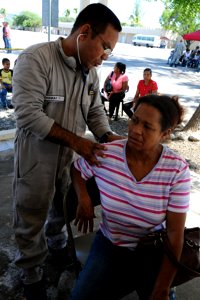 US Navy 081009-N-7955L-002 Lt. Carmo Tomaz examines a patient