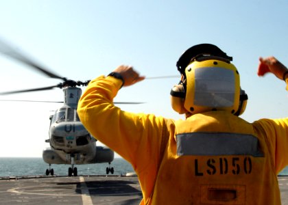 US Navy 081008-N-9134V-104 Boatswain's Mate 2nd Class Guillermo Mendez directs a CH-46E Sea Knight helicopter assigned to Marine Medium Helicopter Squadron (HMM) 264 aboard the amphibious dock landing ship USS Carter Hall (LSD