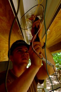 US Navy 081012-N-3595W-048 Air Force Airman 1st Class Andrew Drunkhammer installs lighting for four new classrooms photo