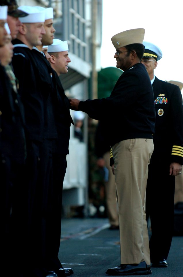 US Navy 081011-N-5758H-185 Vice Adm. Mel Williams Jr. awards a Navy Marine Corps Achievement medal to Electronics Technician Seaman Daniel Miles
