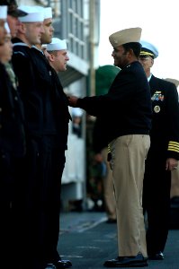 US Navy 081011-N-5758H-185 Vice Adm. Mel Williams Jr. awards a Navy Marine Corps Achievement medal to Electronics Technician Seaman Daniel Miles