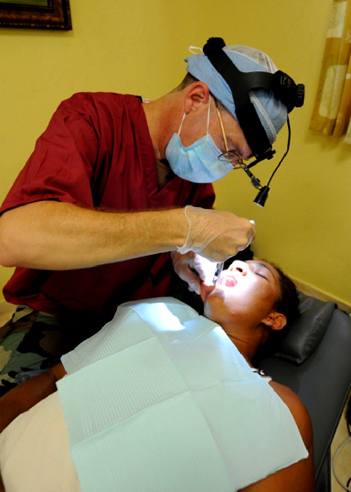 US Navy 081009-N-7955L-033 Cmdr. Michael King performs a dental exam