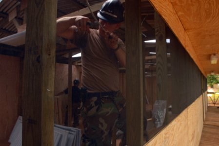 US Navy 081012-N-3595W-226 Air Force Airman 1st Class Andrew Drunkhammer installs lighting for four new classrooms