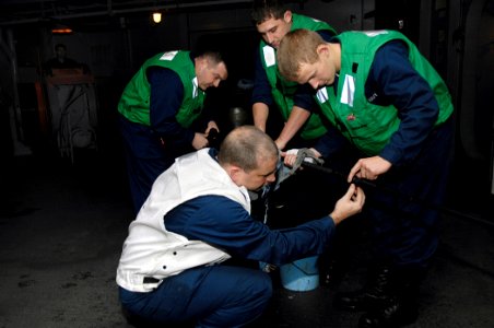 US Navy 081013-N-4954I-003 Chief Cryptologic Technician (Collection) Benjamin Meyer, left, from Fairfax, Va., and Cryptologic Technician (Technical) 3rd Class Josh Bundy, from Denver, inspect the Nixie torpedo countermeasure ca