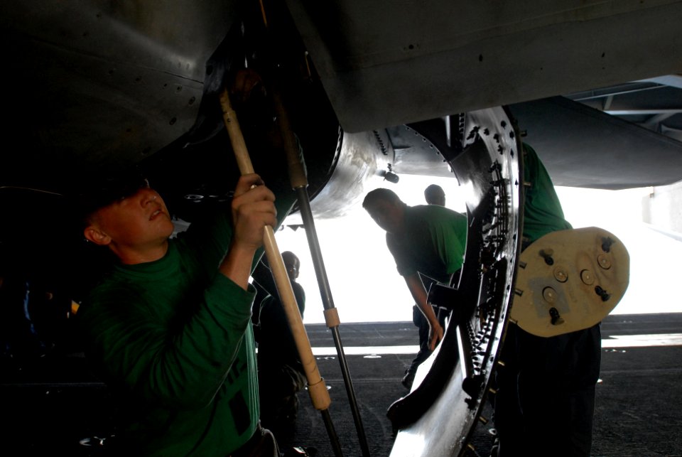 US Navy 081013-N-4995K-057 Aviation Structural Mechanic (Equipment) 2nd Class Michael Chandler works on the engine of a F-A-18E Super Hornet assigned to the