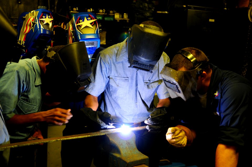 US Navy 081014-N-4515N-168 Hull Technician 3rd Class Aaron Smith teaches Dominican Republic Sailors to weld during a subject matter expert exchange aboard the amphibious assault ship USS Kearsarge (LHD 3)