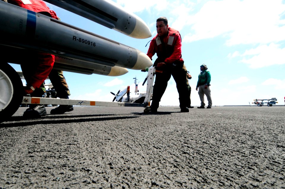 US Navy 081014-N-7918H-136 Aviation Ordnanceman Samuel Gutierrez positions missles to attach them to aircraft aboard the Nimitz-class aircraft carrier USS Theodore Roosevelt (CVN 71)