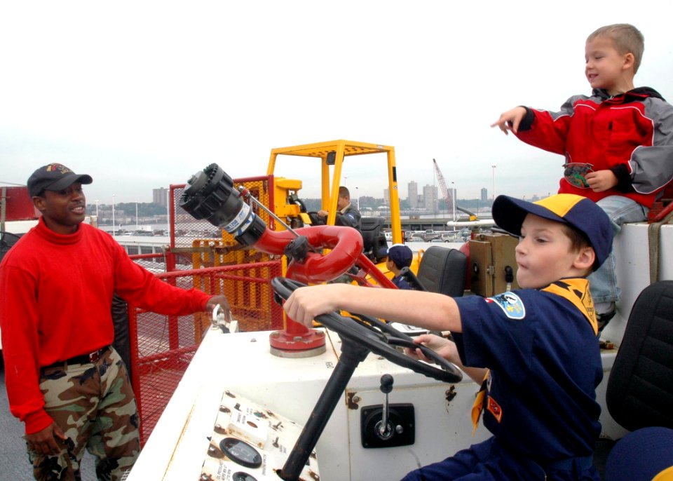 US Navy 081013-N-6439C-030 Aviation Boatswain's Mate Handler 3rd Class Mazi Nickelson speaks to children during a tour of the amphibious assault ship USS Nassau (LHA 4)