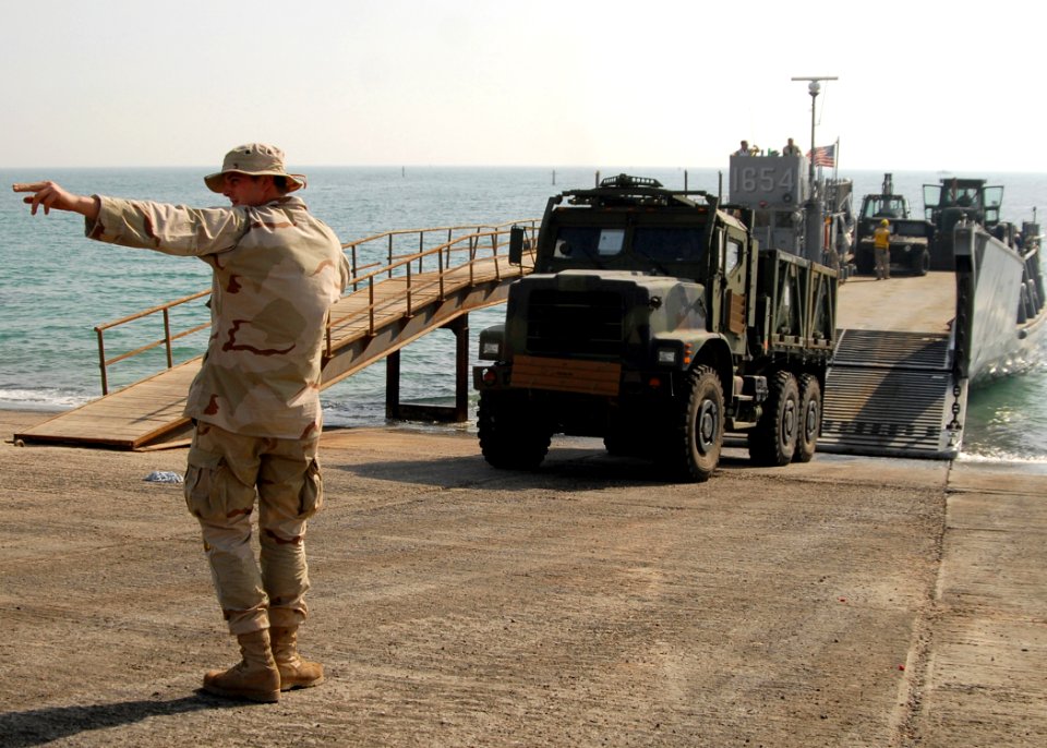 US Navy 081012-N-3392P-131 Boatswain's Mate 3rd Class Cody Horton directs a vehicle offload during amphibious operations with the amphibious dock landing ship USS Carter Hall (LSD 50)