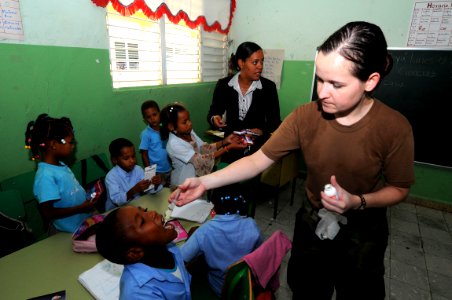 US Navy 081013-N-9774H-056 Hospital Corpsman 1st Class Sharon Vigue, a preventive medical technician embarked aboard the amphibious assault ship USS Kearsarge (LHD 3), gives elementary school children de-worming medicine during photo